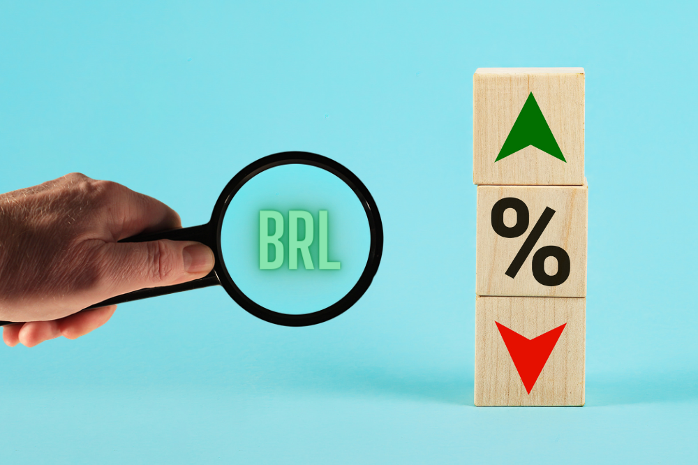 mão com lupa em cima da palavra BRL e ao lado blocos de madeira, simbolizando taxas BRL na fatura do cartão de crédito