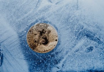 Símbolo dourado bitcoin congelado e coberto com gelo conceito de crise do inverno cripto